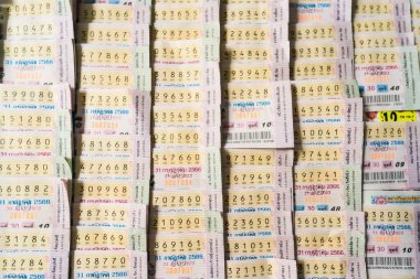 Bangkok, Tayland - 18 Aralık 2024: Bangkok, Tayland 'da birden fazla satırda numaralar ve ayrıntılar gösterilerek yan yana dizilmiş renkli piyango biletleri yığını