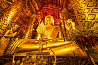 Ayutthaya, Tayland - 10 Mart 2025: Wat Phanan Choeng tapınağında altın sütunlar ve Ayutthaya, Tayland 'da çevreleyen karmaşık desenler ile altın Buda heykeli