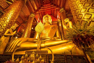 Ayutthaya, Tayland - 10 Mart 2025: Wat Phanan Choeng tapınağında altın sütunlar ve Ayutthaya, Tayland 'da çevreleyen karmaşık desenler ile altın Buda heykeli