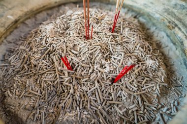 Tütsü çubukları ve küllerin tapınak tütsü yakma makinesinde yakın plan, ruhani ayinleri ve kültürel gelenekleri sembolize ediyor.