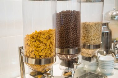 Kahvaltı büfesinde mısır gevreği, çikolata topu ve yulaf dolu mısır gevreği kutularına yakından bakın.