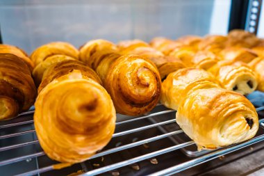 Fırında yeni pişmiş kruvasan ve hamur işleriyle dolu bir vitrin.