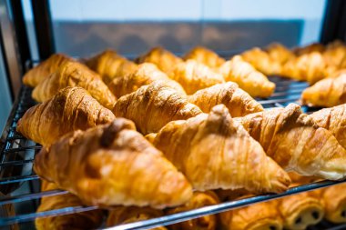 Fırında yeni pişmiş kruvasan ve hamur işleriyle dolu bir vitrin.