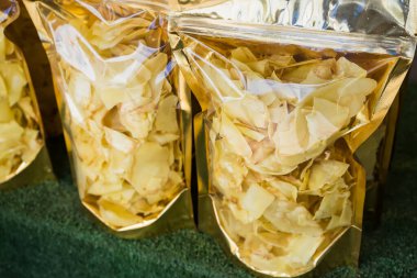 Bir markette satılmak üzere altın mühürler sergilenen şeffaf torbalarda paketlenmiş kurutulmuş Durian çipleri.
