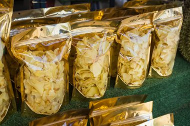 Bir markette satılmak üzere altın mühürler sergilenen şeffaf torbalarda paketlenmiş kurutulmuş Durian çipleri.