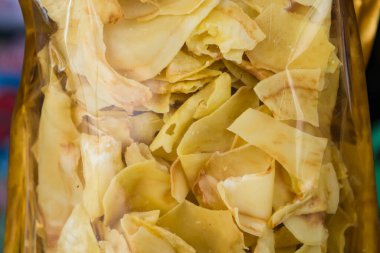 Bir markette satılmak üzere altın mühürler sergilenen şeffaf torbalarda paketlenmiş kurutulmuş Durian çipleri.