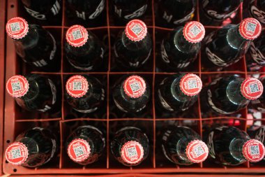 Bangkok, Tayland - 15 Mayıs 2025: Coca-Cola ve Fanta 'nın yer aldığı renkli cam soda şişeleri, düzgün bir içecek dağıtım ortamında düzenlenmiştir