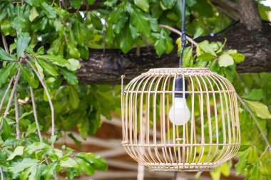 İki bambu fener açık havada, yemyeşil bir dağ zemininde asılı. Huzurlu ve doğal bir ortam yaratıyor.
