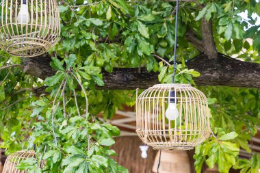 İki bambu fener açık havada, yemyeşil bir dağ zemininde asılı. Huzurlu ve doğal bir ortam yaratıyor.
