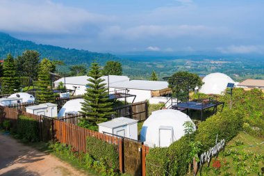 Phetchabun, Tayland - Haziran, 06, 2025: Tayland 'ın Phetchabun kentinde bulutların dağıtıldığı yemyeşil tepelerde kurulmuş ekolojik bir tatil beldesindeki modern jeodezik kubbelerin manzarası