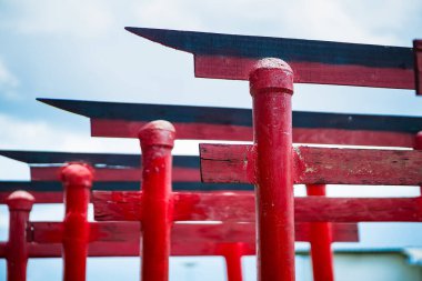 Japon kültürünü ve ruhaniliğini temsil eden mavi arkaplanlı geleneksel kırmızı torii kapılarının yakın görüntüsü