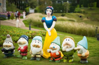 Phetchabun, Tayland - Haziran 08, 2025: Pamuk Prenses ve Yedi Cücelerin yemyeşil bir bahçe ortamında bulanık arkaplan Phetchabun, Tayland