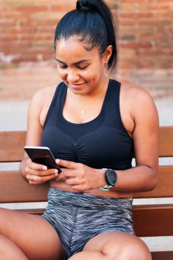 Genç sporcu, spor, şehir sporu ve sağlıklı yaşam tarzı kavramından önce cep telefonunu kullanıyor.