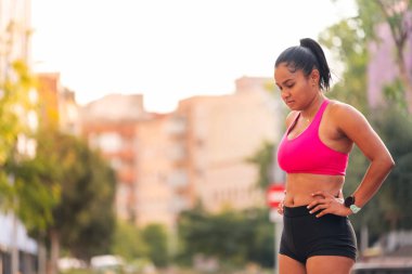 Bayan sporcu, şehir atletizm pisti, şehir sporları ve sağlıklı yaşam tarzı konseptindeki antrenmanında soluklanıyor.