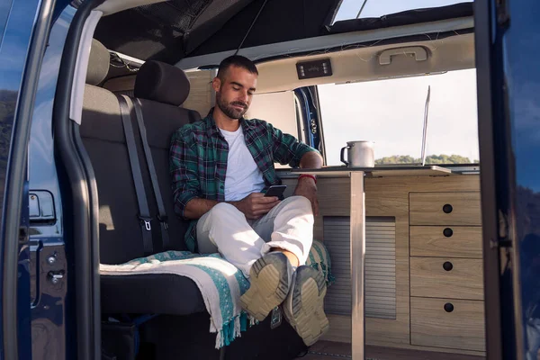 Jovem Sentado Dentro Sua Van Campista Usando Seu Telefone Celular — Fotografia de Stock
