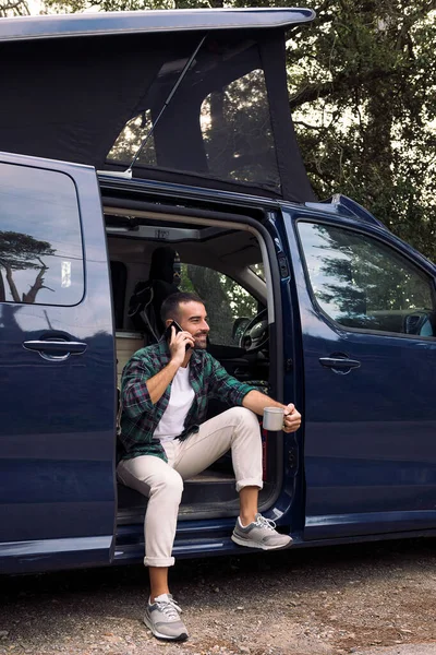 Jovem Sorridente Usando Seu Telefone Celular Sentado Porta Sua Van — Fotografia de Stock
