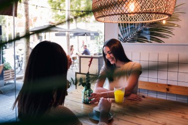two young women on a date having a drink in a coffee shop, concept of friendship and love between women