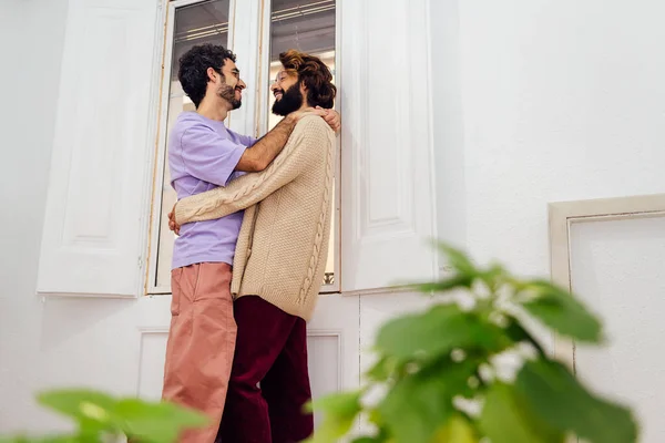 Homosexuell Männliches Paar Lächelt Glücklich Und Umarmt Fenster Ihrem Wohnzimmer — Stockfoto