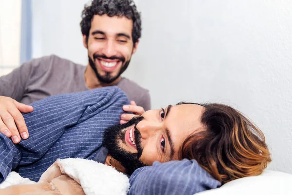 stock image gay male couple relaxing together at bed and smiling happy in the morning, concept of real people lifestyle and love between people of the same sex