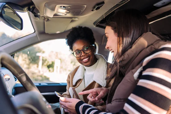 stock image two young women in camper van planning road trip on the phone, concept of adventure and travel with best friend