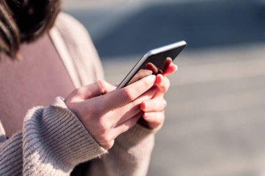Cep telefonu kullanan genç bir kadının ellerini kapatın, modern yaşam tarzı ve iletişim teknolojisi kavramı, metin için kopyalama alanı