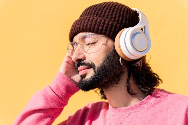 Junger Mann Hört Musik Über Kopfhörer Mit Gelbem Hintergrund Konzept — Stockfoto