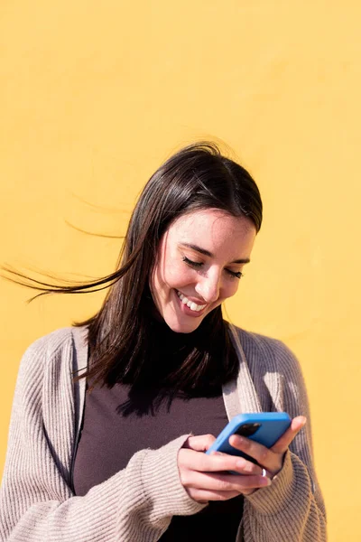 Πορτρέτο Μιας Χαμογελαστής Νεαρής Γυναίκας Που Χρησιμοποιεί Κινητό Τηλέφωνο Κίτρινο — Φωτογραφία Αρχείου