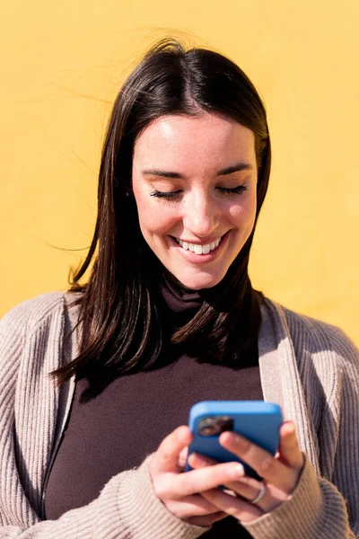 Πορτρέτο Μιας Χαμογελαστής Νεαρής Γυναίκας Που Χρησιμοποιεί Κινητό Τηλέφωνο Κίτρινο — Φωτογραφία Αρχείου