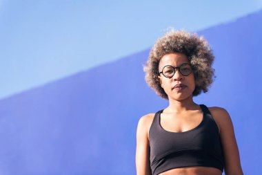 Güneşli bir günde açık havada, ciddi bir Afro-Amerikan sporcusunun düşük açılı portresi, spor anlayışı ve aktif yaşam tarzı, metin için kopyalama alanı