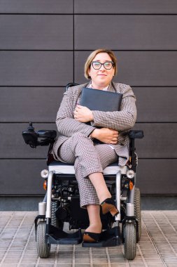 Kameraya, girişimcilik ve çeşitlilik kavramına bakarak tekerlekli sandalye kullanan gülümseyen iş kadını, metin için kopyalama alanı