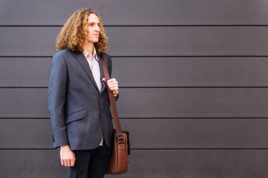 Yanlara bakan çantalı şık genç girişimci, iş konsepti ve modern şehir yaşam tarzı, metin için kopyalama alanı