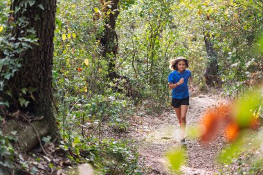 Ormanda koşan bir kız, çocuklar için spor konsepti ve sağlıklı yaşam tarzı, metin için kopyalama alanı
