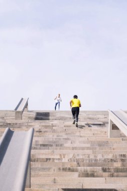 Üst düzey bir sporcunun merdivenlerde antrenman yaparken orta yaşlarda aktif ve sağlıklı yaşam tarzı kavramından cesaret alırken çekilmiş dikey fotoğrafı, metin için yer kopyalama