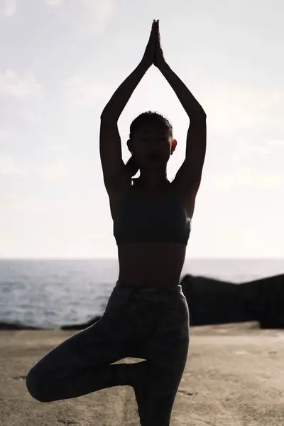 Rétroéclairage Jeune Femme Tenue Sport Faisant Position Arbre Yoga Par Photo De Stock