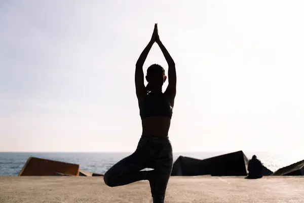 Rétroéclairage Jeune Femme Tenue Sport Faisant Position Arbre Yoga Par Image En Vente