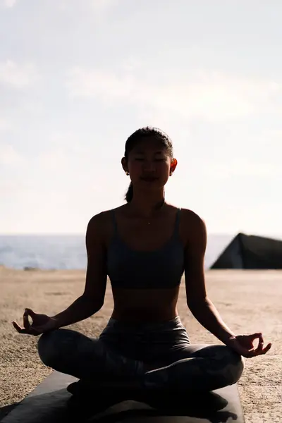 Подсветка Молодой Женщины Занимающейся Медитацией Моря Сидящей Скрещенными Ногами Концепцией Стоковое Изображение