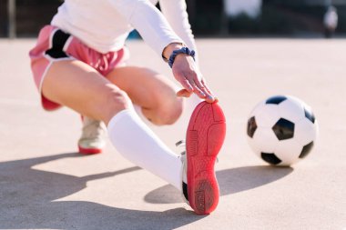 Futbol sahasında bacak esneten futbol topuyla tanınmayan bir kadın spor anlayışı ve aktif yaşam tarzı.