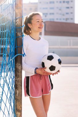 Kafkasyalı bayan futbolcu elinde futbol topu ile kent sahasının hedefine, spor anlayışına ve aktif yaşam tarzına dayanıyor.