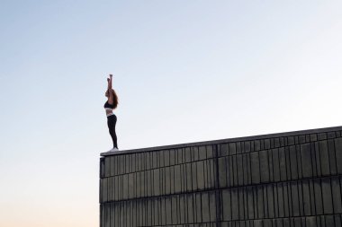 Spor kıyafetleri içinde tanınmayan bayan sporcuların gün batımına hayranlıkla bakması antremandan sonra çatıdan yükselen kollarıyla, kentsel spor anlayışı ve sağlıklı yaşam tarzıyla