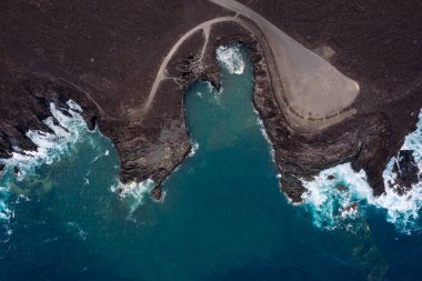 top view of foamy sea breaking over the volcanic coast of Los Hervideros in Yaiza, Lanzarote at Canary Islands, Spain, concept of wild nature clipart