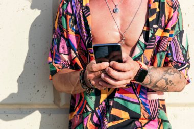 Güneşli bir günde cep telefonuyla sosyal medyada sohbet eden hipster 'ın ekin görüntüsü