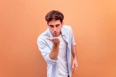 Genç bir adam kameraya olumlu ve dostane bir tavırla bakarken el ele öpüşüyor. Aşk kavramı, metin için telif alanı.