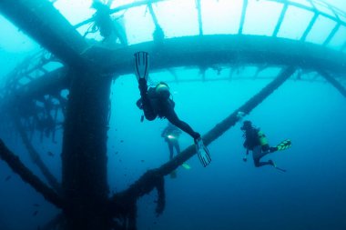 Tanınmayan dalgıçlar, batık bir enkazın yanında dalgıçlık, dalgıçlık ve sualtı macerası konsepti.