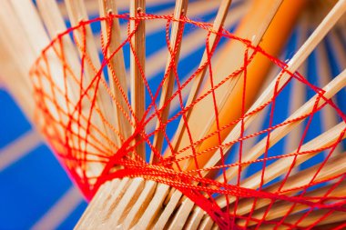 Sıkıca örülmüş kırmızı iplikler. İpliklerin eşkenar dörtgen şeklinde bağlanması. Yüksek kalite fotoğraf