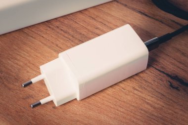 Ahşap yüzeyde beyaz elektronik şarj aleti, yakın çekim. Yaratıcı ya da profesyonel projeler için harika