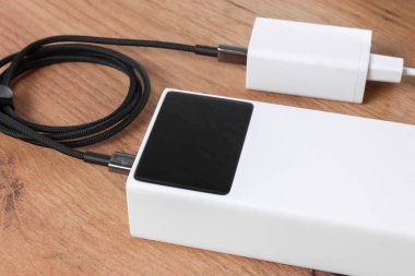 Tahta yüzeyde güç bankası ve şarj aleti. Çoklu amaçlar için çok yönlü resim