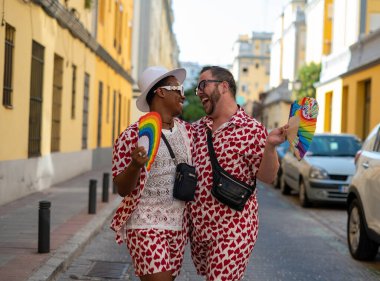 LGTBI bayrağı renginde el yelpazeli eşcinsel bir çift.