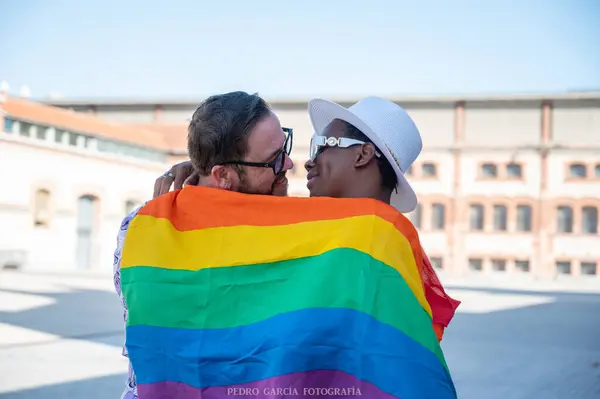 Çok ırklı eşcinsel bir çiftin portresi Sokakta Igbt bayrağı dalgalandırıyor