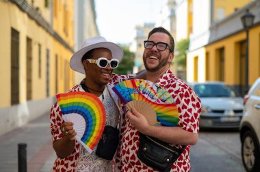 LGTBI bayrağı renginde el yelpazeli eşcinsel bir çift.