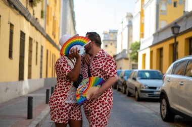 LGTBI bayrağı renginde el yelpazeli eşcinsel bir çift.